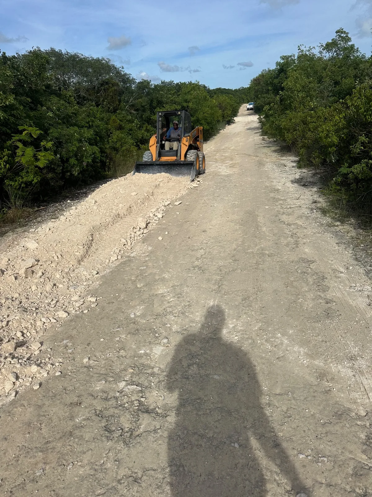 Skid steer grading an access road